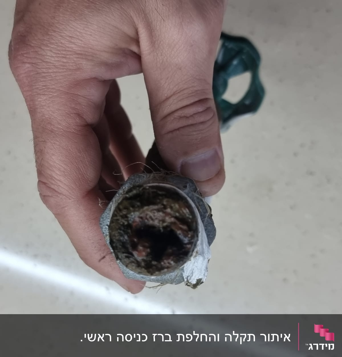 יד מחזיקה צינור סתום עם לכלוך